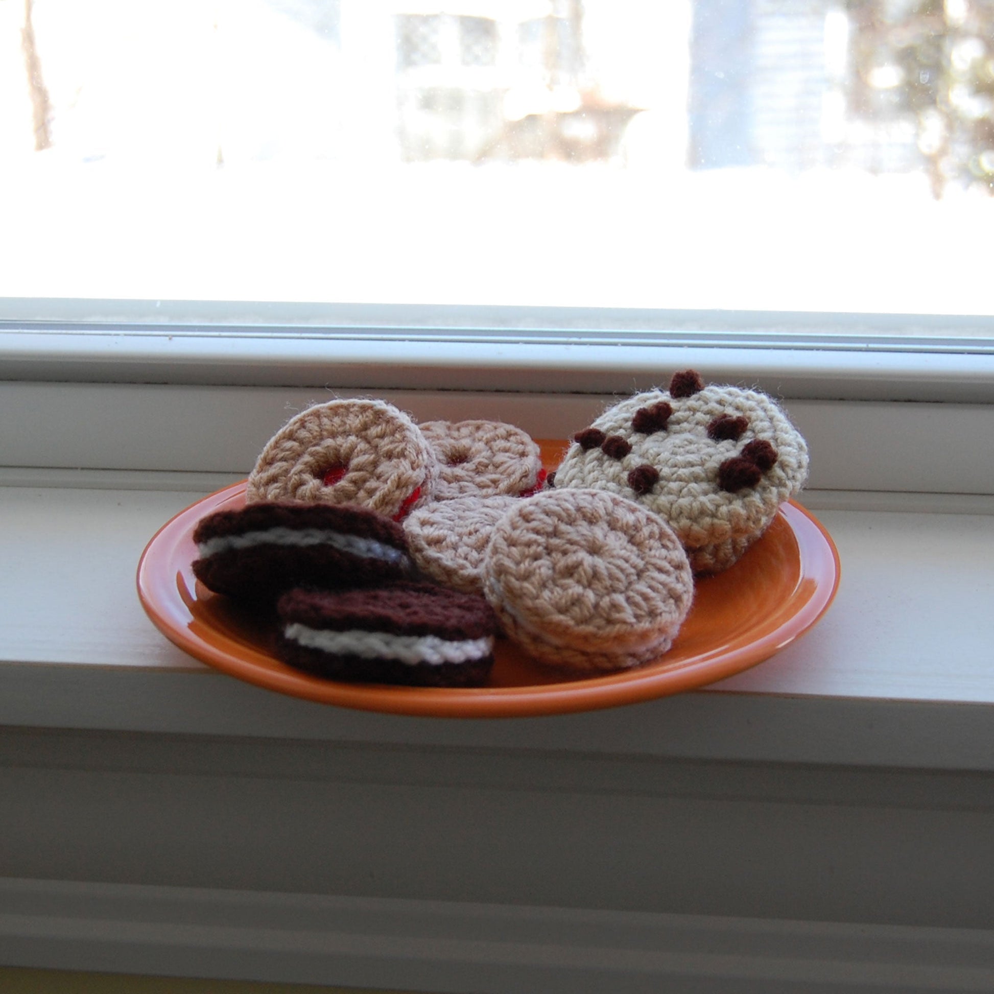 plate of crocheted cookies by a window