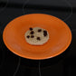 chocolate chip crochet cookie on an orange plate